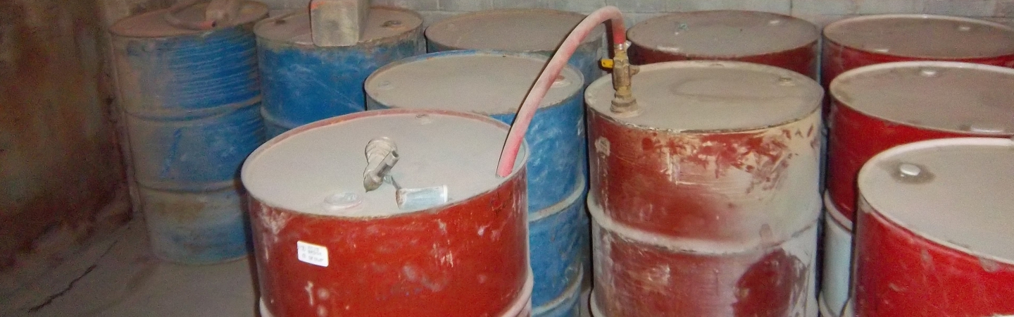 55-gallon drums stored in a dirty lube room